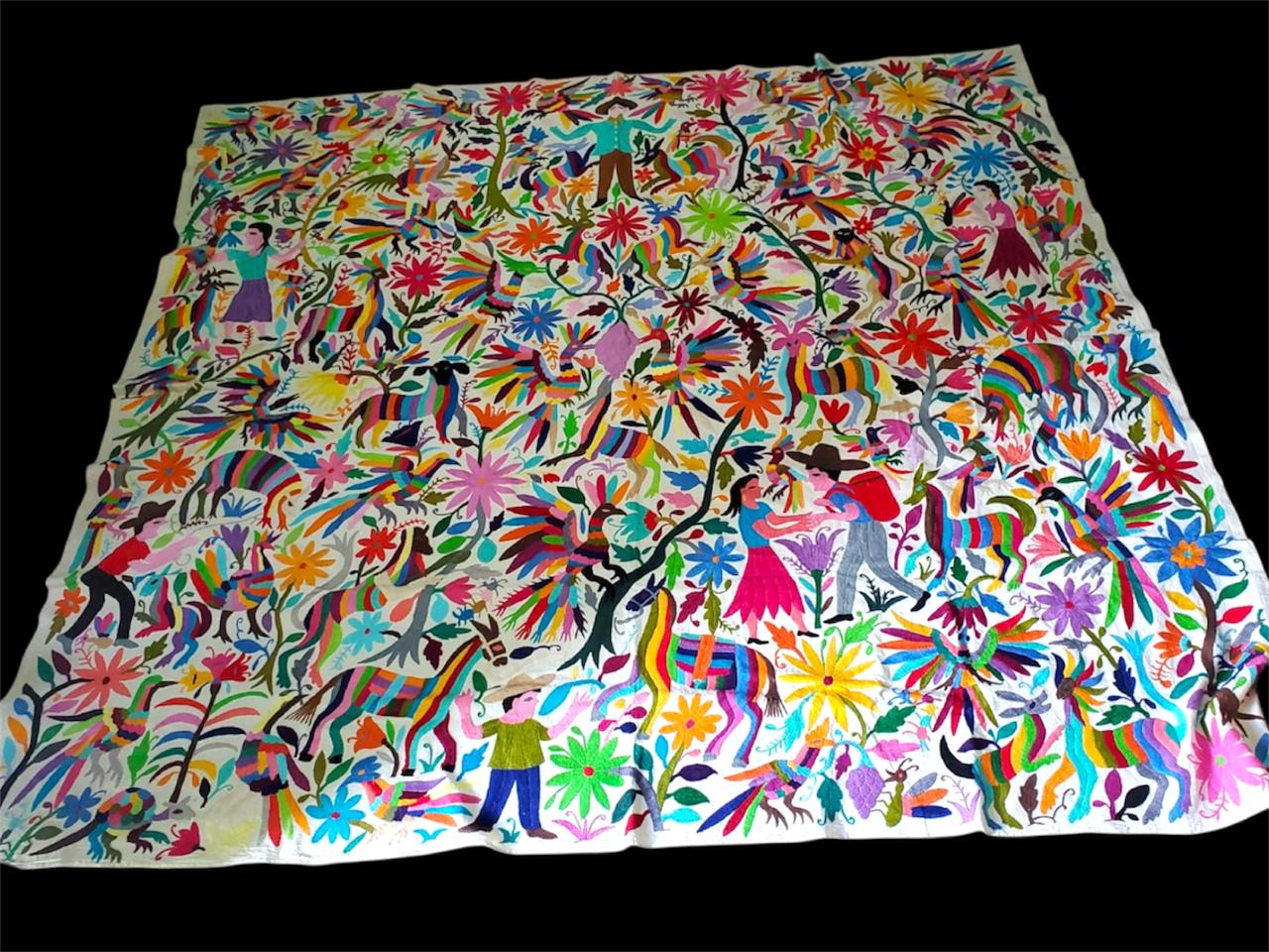 Otomi tapestry with intricate patterns and characters on a black background