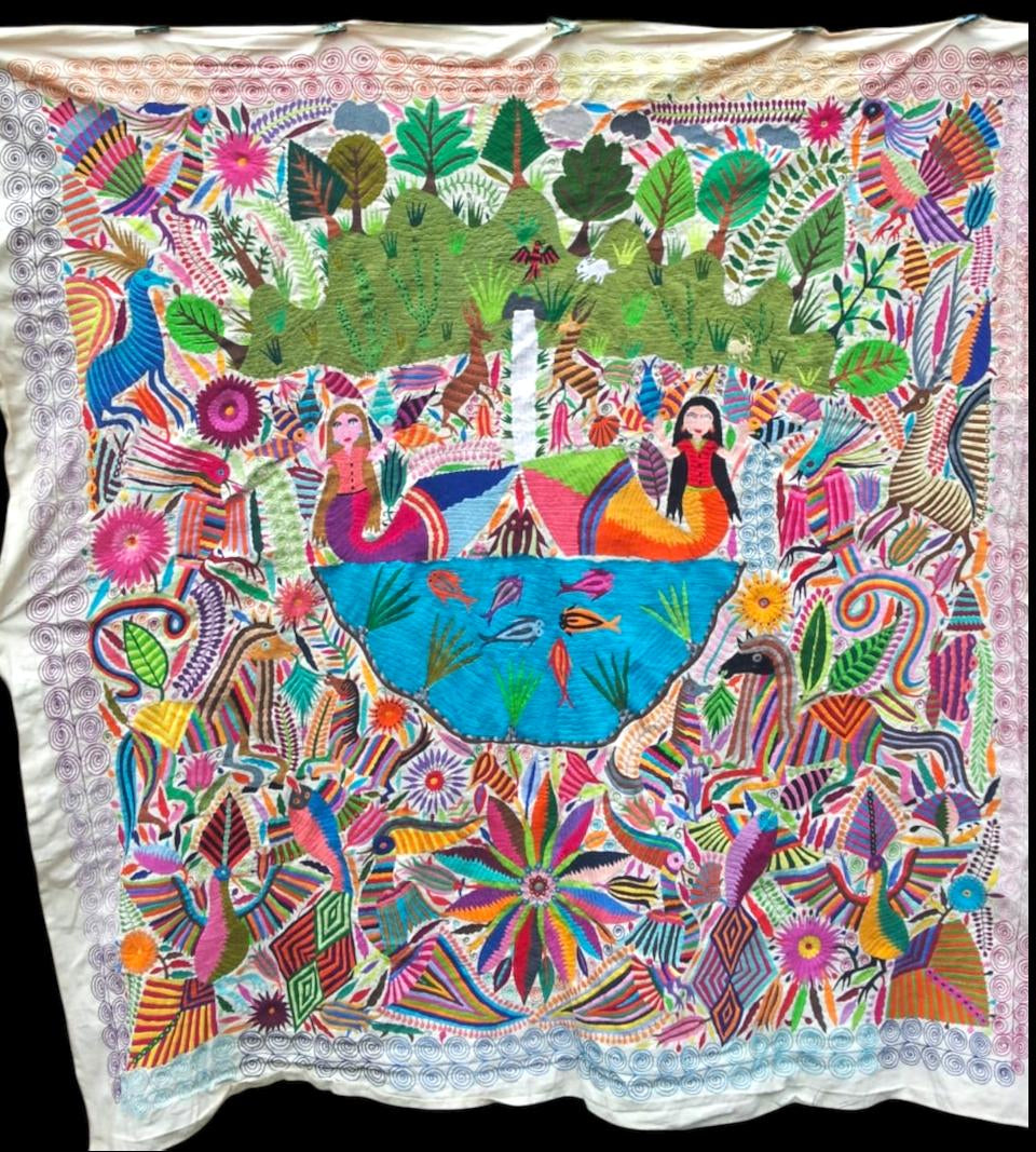 Extra large Otomi tapestry wall art hand-embroidered in Mexico, featuring a vibrant depiction of two mermaid in a forest setting with a variety of wild flora and fauna.