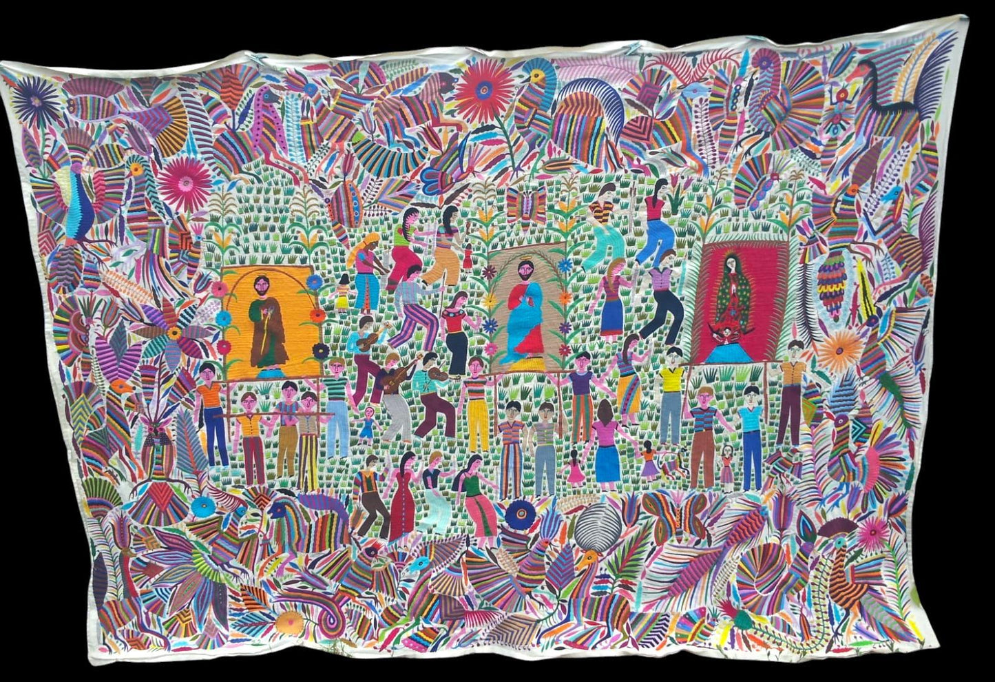 Extra large Otomi tapestry wall art hand-embroidered in Mexico, featuring vibrant colors and intricate designs with flora, fauna and religious motifs.