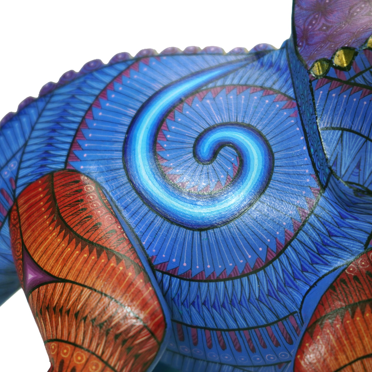 Close-up of a colorful, intricately designed wooden folk art animal sculpture with blue and red patterns.