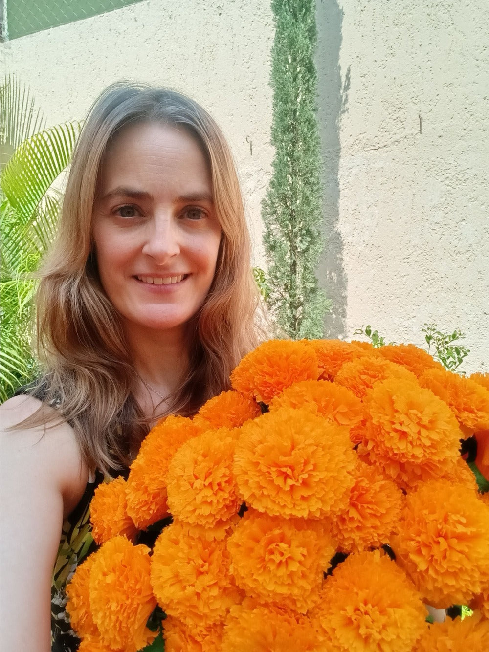 Mexican decorations expert Aprylle holding paper Cempasuchil Marigolds Day of the Dead flowers