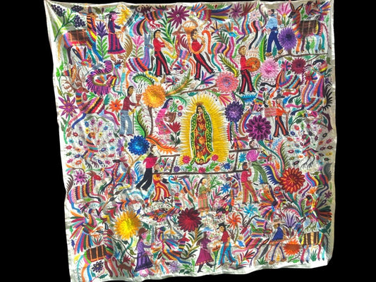 Extra large Otomi tapestry wall art hand-embroidered in Mexico, featuring a vibrant and colorful design with the Virgin Mary in the center, surrounded by floral patterns and figures.