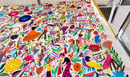 Colorful traditional Otomi hand embroidered Mexican tapestry with intricate patterns and vibrant colors.