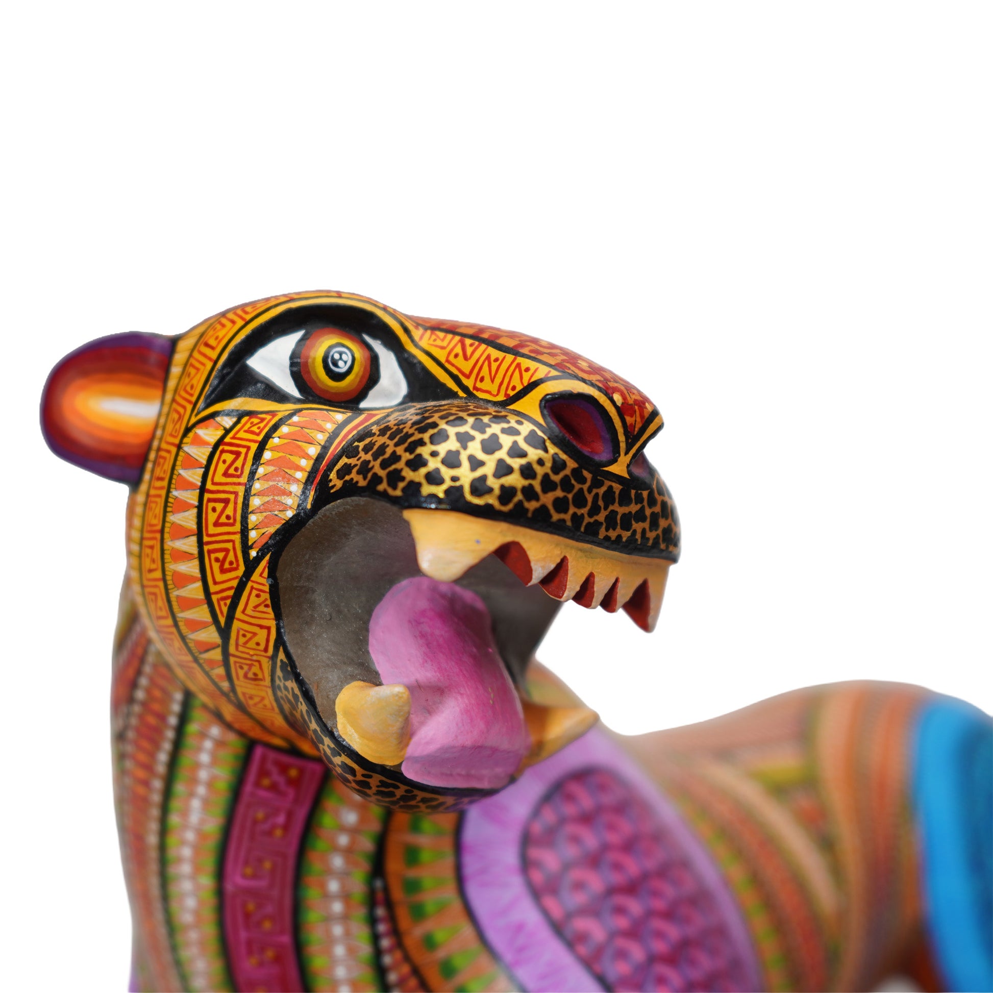 Colourful alebrije of a jaguar sculpture with intricate hand-painted patterns, on a white background.