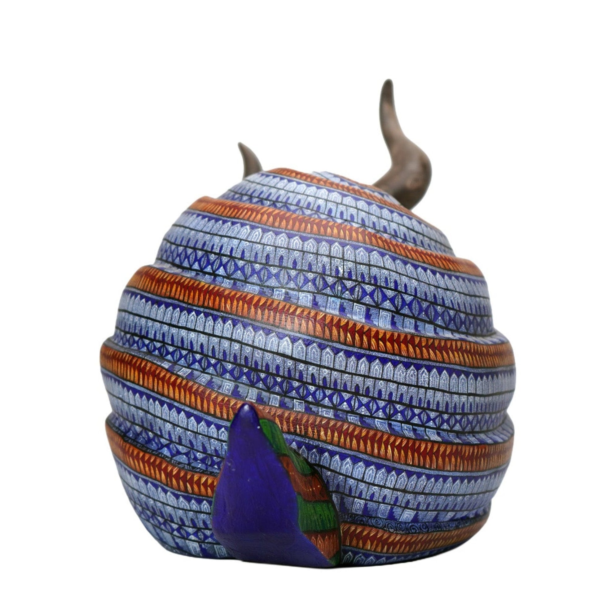 Decorative oaxacan wood carving with intricate painted pattern and horns on a white background