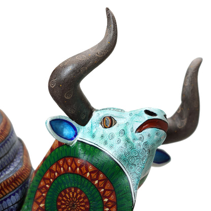 Decorative bull head with large horns and colorful patterns on a white background.