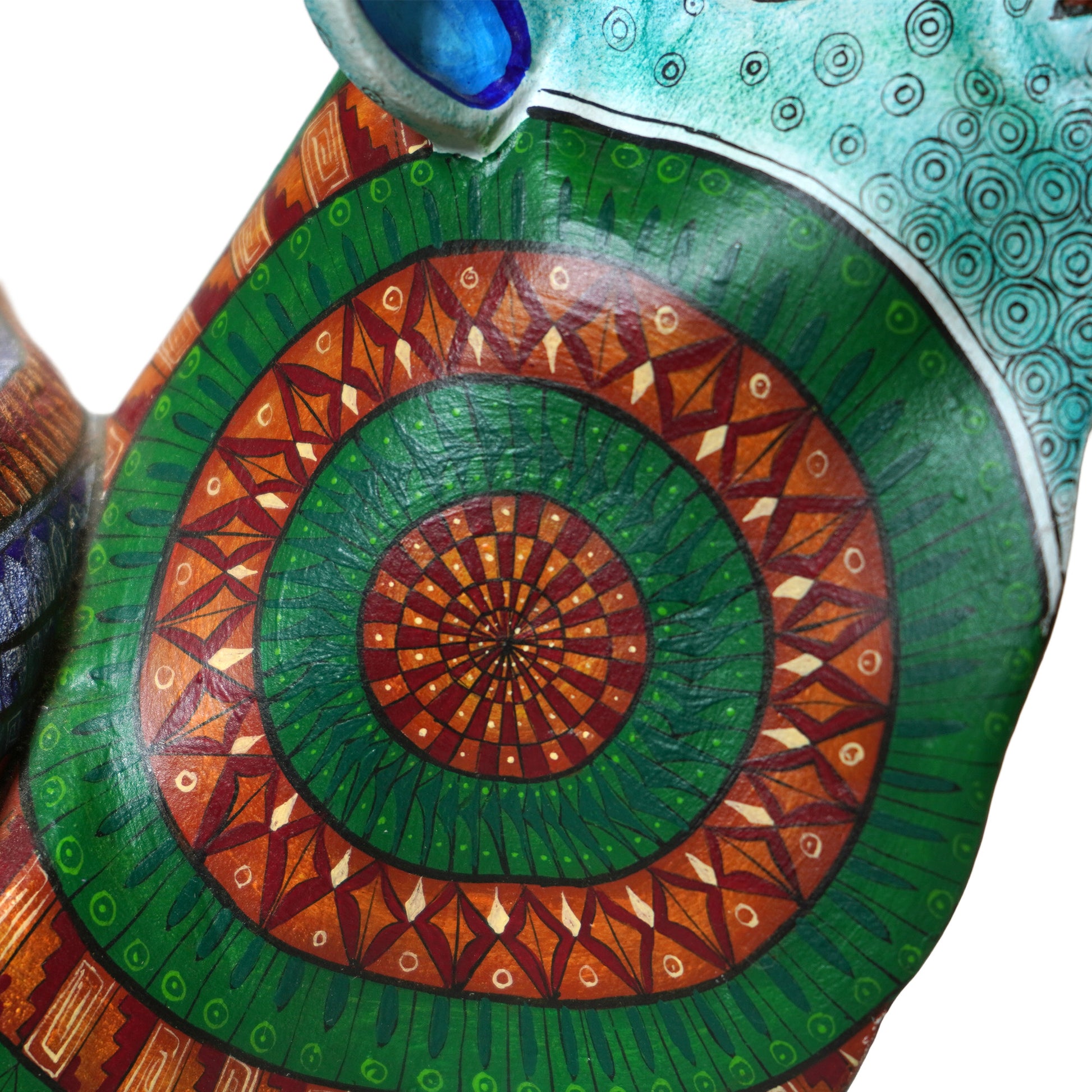 Decorative sculpture with green and brown spiral pattern on a white background