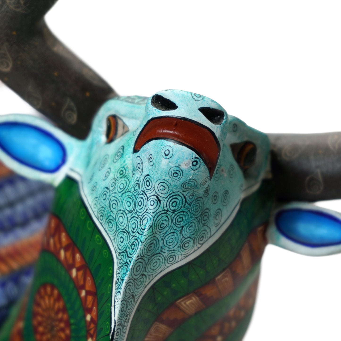 Colorful bull head art piece with intricate painted patterns on a white background.